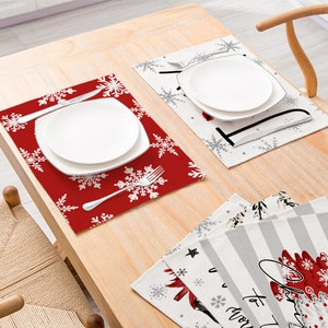 Red Christmas placemat with snowflake prints on a wooden table with dining set