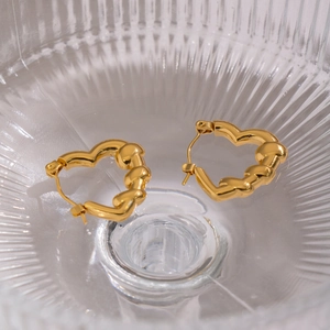 French retro heart-shaped earrings in 18K gold plated stainless steel on glass surface