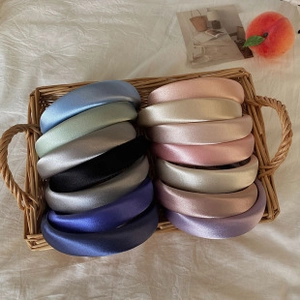 Assorted thick sponge headbands in satin finish displayed in a woven basket