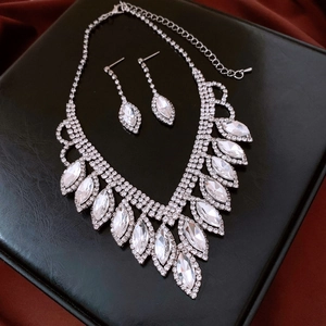 Close-up of silver water drop tassel necklace set with marquise cut crystal on black leather