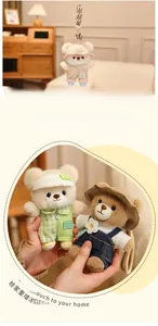 Detail of cute teddy bear plush keychain wearing green plaid overalls and a khaki bucket hat
