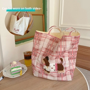 Detail of checkered canvas tote bag with plush dachshund embroidery and dual-sided design