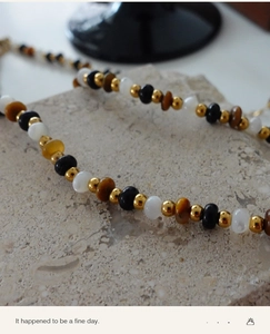 Macro shot of tiger eye stone beads and golden metallic accents on a stone base
