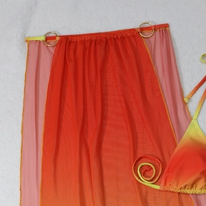 Detail of orange gradient mesh skirt with gold metal ring and matching bikini top