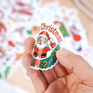 Close-up of holographic laser Christmas sticker with Santa Claus and festive wreath