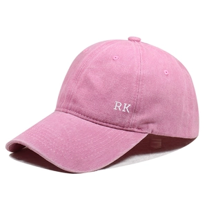 Detail of pink washed cotton baseball cap featuring RK embroidery and side stitching