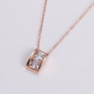 Close-up of rose gold rectangular necklace pendant with two sparkling square zircons