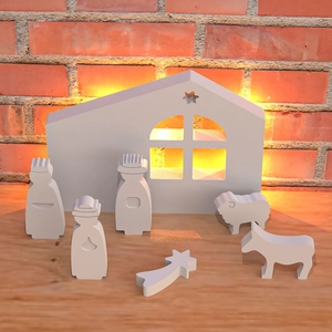 Detalle del molde de silicona del pesebre nórdico blanco con luz de fondo cálida