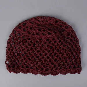 Détail de la maille crochetée rouge foncé avec design à bordure ondulée festonnée