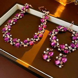 Close-up of vintage gold floral jewelry set with purple gemstones in a gift box
