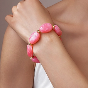 Detailed shot of pink marble beads and gold metallic spacers on a stylish beaded bracelet