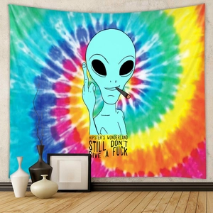 Close-up of bohemian tie-dye tapestry featuring a green alien in an indoor home setting