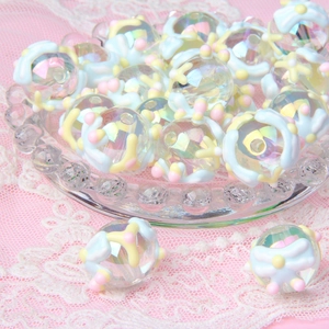 Detailed view of hand-painted acrylic beads with colorful floral patterns on lace