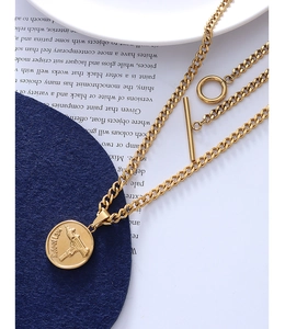 Detail of gold-layered Uzi pendant necklace with OT toggle clasp on vintage magazine