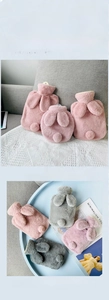 Close-up of soft faux rabbit fur hot water bottles with cute bunny ears and tails
