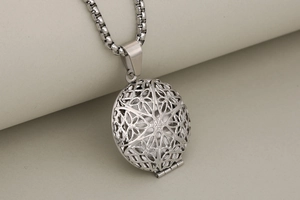 Macro detail of silver vintage locket pendant with intricate cutout patterns