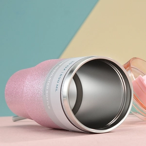 Detail of 30oz pink glitter vacuum insulated tumbler with lid on colorful background