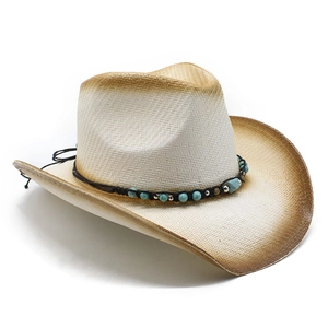 Detail of straw cowboy hat featuring burnt edges and turquoise bead decorative band