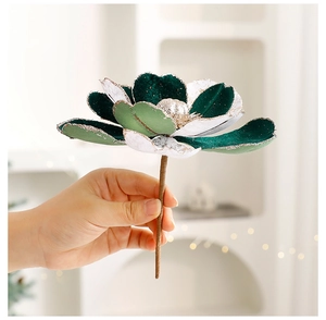 Détail d'une fleur de Noël en velours magnolia avec bords pailletés argentés à la main