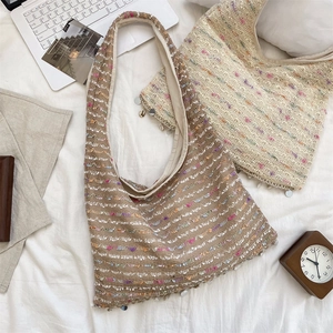 Detail of knit crochet tote bag with colorful threads and sequin tassel charms