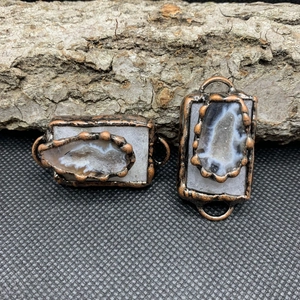 Primer plano de conectores de geoda de ágata con borde de cobre retro en corteza