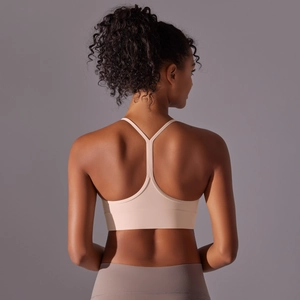 Detailed back view of a beige racerback sports bra with seamless elastic fabric