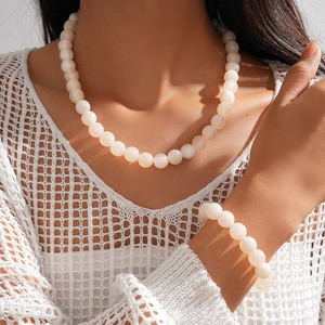 Bohemian acrylic beaded necklace and bracelet set in milky white on a female model