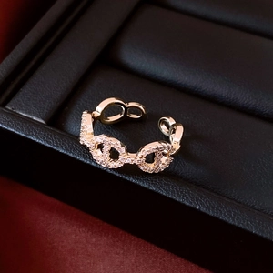 Macro shot of 14K gold plated pig nose ring with zircon pavé on black leather