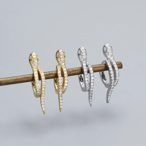 Detail of snake shaped earrings in gold and silver finish with pavé set crystals