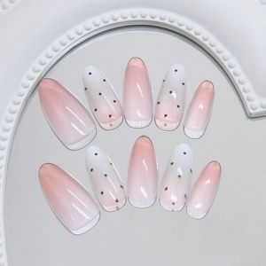 Pink and white gradient almond press-on nails with dark dots and cat eye shimmer effect