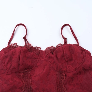 Detail of dark red lace texture with delicate floral patterns on a slim strap dress