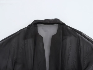 Gros plan du col en maille transparente noire sur une robe moulante élégante