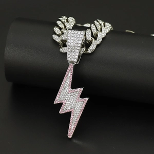 Detailed close-up of a silver Cuban chain with a lightning bolt pendant and pink rhinestones