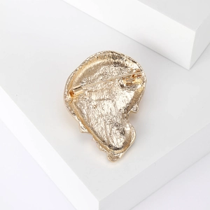 Back view of colorful skull brooch with gold-tone finish and secure pin fastener