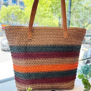 Large colorful striped raffia tote bag with brown leather handles for summer beach use