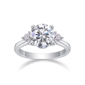 Macro shot of silver three-stone moissanite ring with round brilliant cut in 4-prong setting
