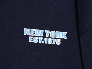 Detailed close-up of NEW YORK EST.1975 print on dark blue hooded tracksuit vest