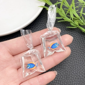 Macro shot of creative resin goldfish charm in a miniature water bag for DIY earrings