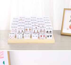 Macro shot of tiered wooden earring display stand with jewelry cards for retail storage