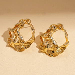 Detailed view of golden irregular pleated geometric earrings with a metallic textured finish