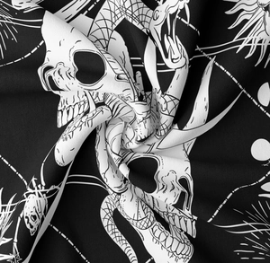 Detail of gothic tapestry fabric with snake and skull print showing texture and drape