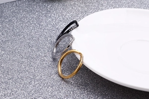 Gros plan de trois bagues empilables en noir, argent et or rose avec cristaux pavés