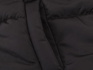 Close-up of black quilted fabric showing premium zipper details and high-quality stitching