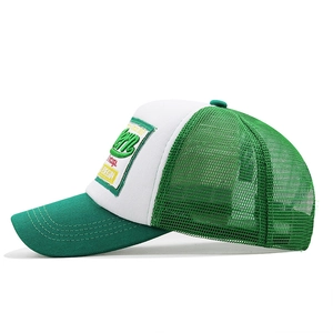 Side view of white and green mesh trucker hat with 1985 vintage embroidery patch