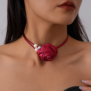 Detail of red satin rose choker with white pearls and double-strand cord design