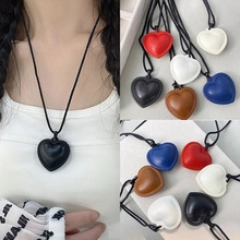 Detailed view of heart pendant necklace with leather texture in multiple color options