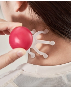 Detailed view of red handheld massager with white claws massaging the neck area