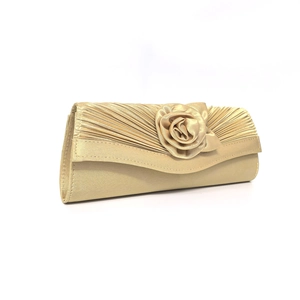 Detail of champagne satin evening clutch featuring 3D rose and pleated texture