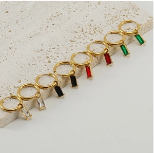 Detail van vier paar gouden oorringen met hangers van smaragd, robijn, zwart en helder zirkoon