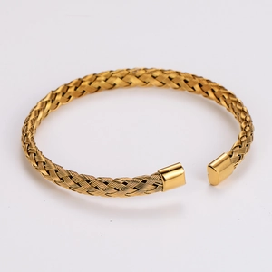 Detailed macro shot of the golden braided texture and smooth finish of the cuff bracelet
